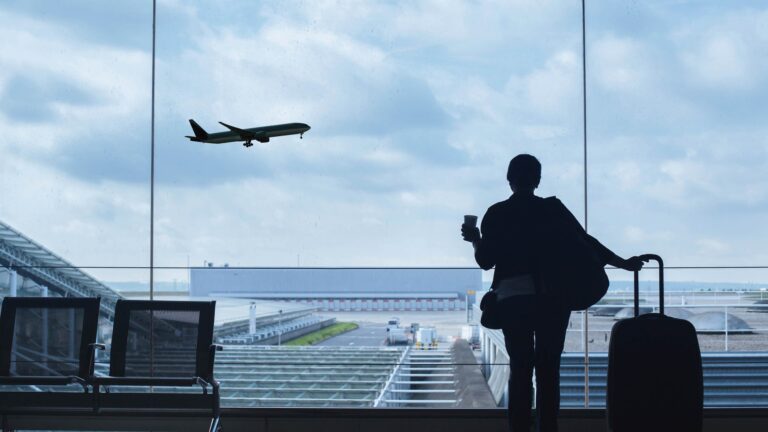 Girl at airport watching jet take off