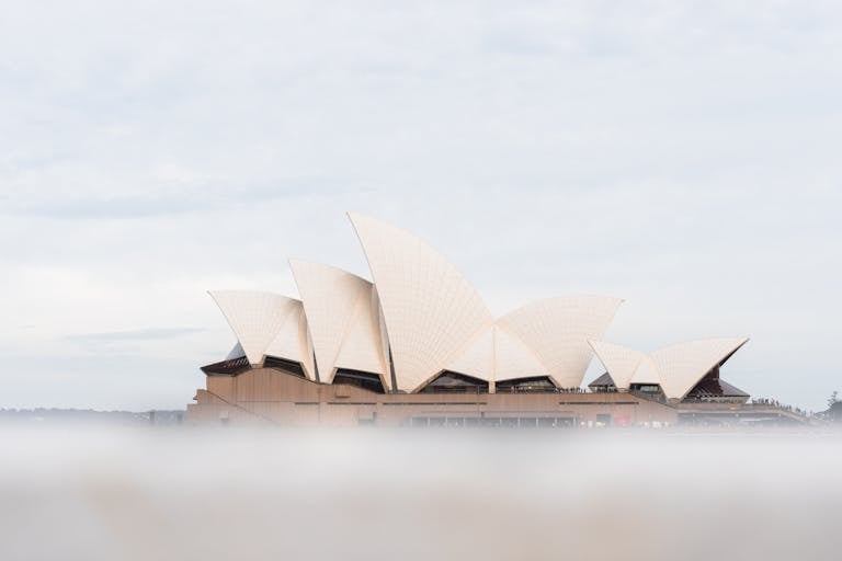 A foggy view of the iconic Sydney Opera House in Australia, capturing its distinctive sail-like architecture.