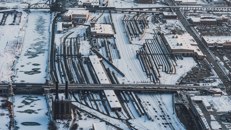 Aerial winter view of snow-covered rail yards and industrial area in Chicago, Illinois.