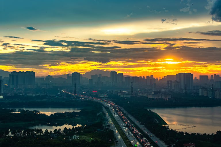 Breathtaking view of Hanoi skyline during sunset with vibrant colors and a river reflecting the golden hues.