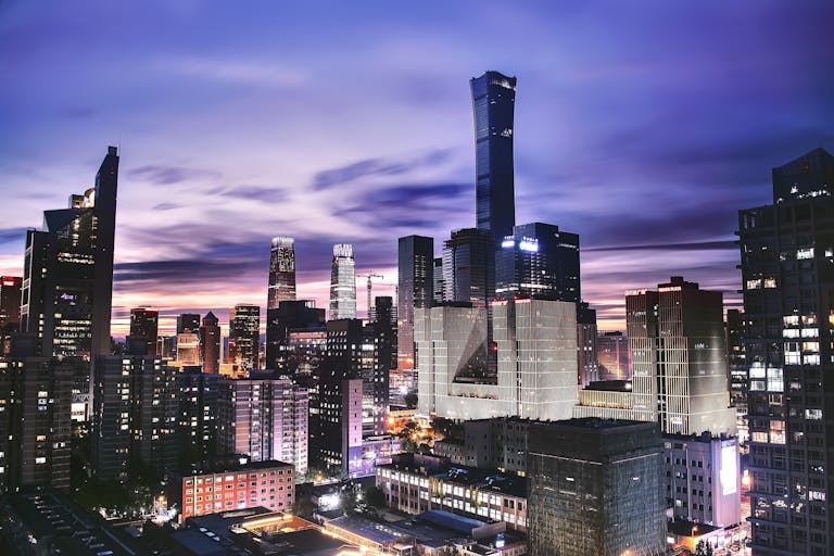 Explore the vibrant skyline of Beijing as twilight paints the horizon in this stunning aerial shot.