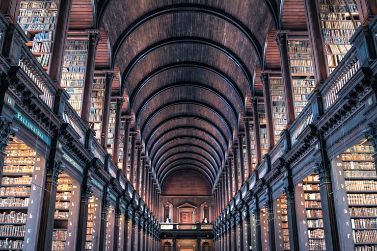 Explore the majestic architecture of an ancient library with classic wooden arches and towering book-filled shelves.